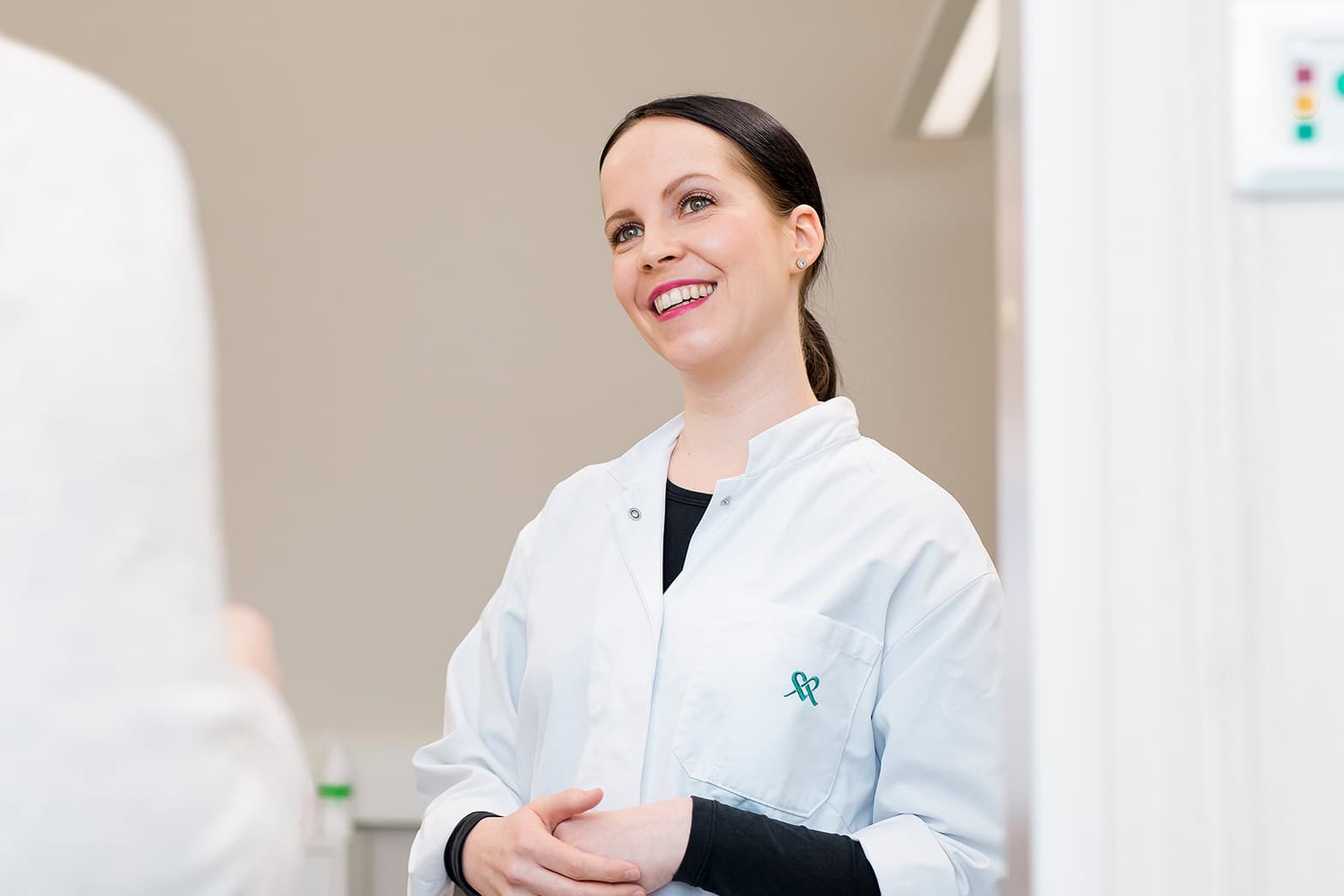 Gynekologi eli naistentautien ja synnytysten erikoislääkäri hymyilee asiakkaalle.