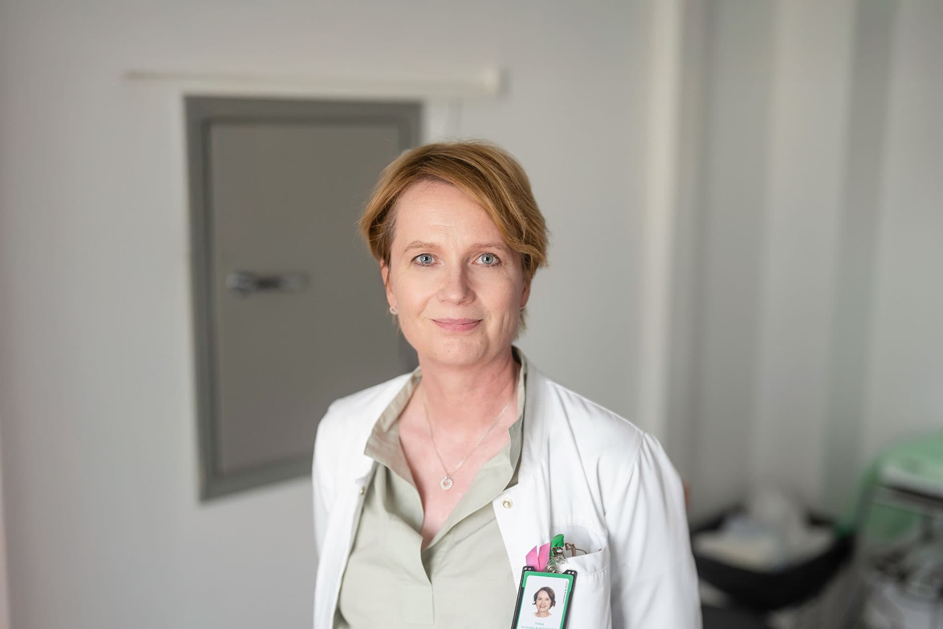 Mehiläinen’s physician Tiina smiles for the camera in the appointment room.