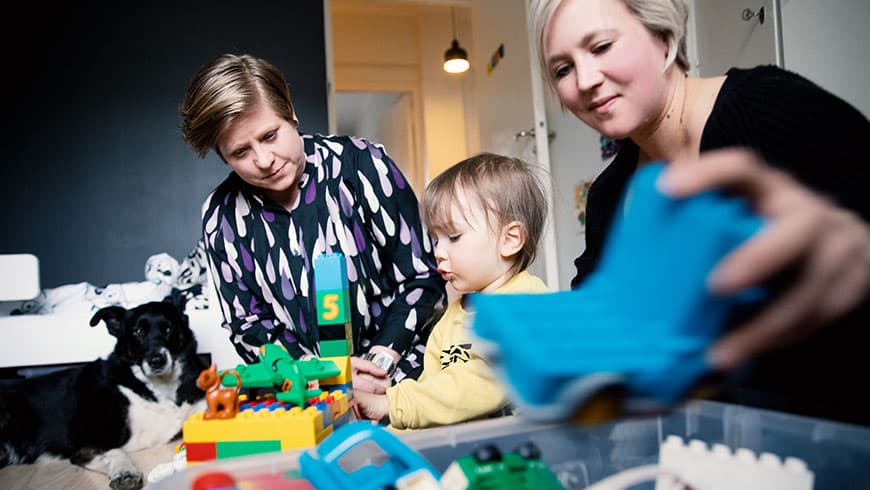 Sara ja Essi leikkivät lastenhuoneessa lapsensa kanssa.
