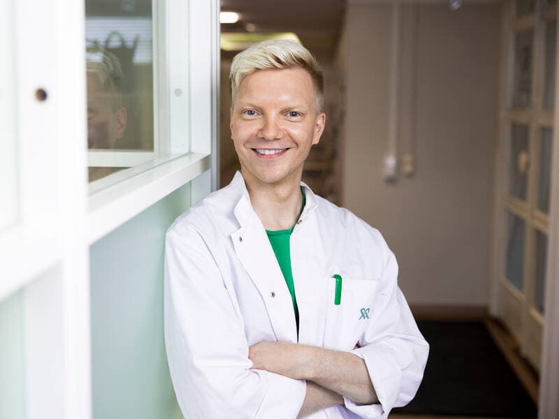 A Mehiläinen physician stands in the medical clinic hallway, posing for the camera.