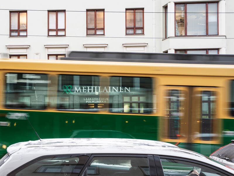 A tram in Helsinki with a Mehiläinen advertisement on its side.