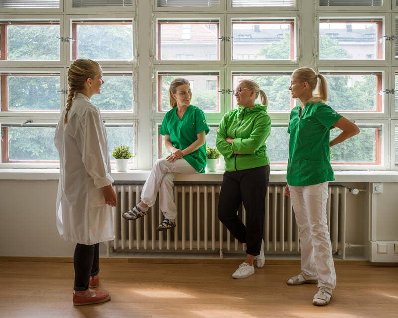Mehiläinen personnel are talking to each other in the medical clinic corridor.