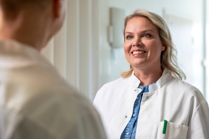 Mehiläisen naislääkäri hymyilee asiakkaalle.